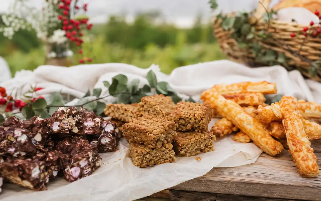 Rocky road, flapjacks and cheese straws on parchment